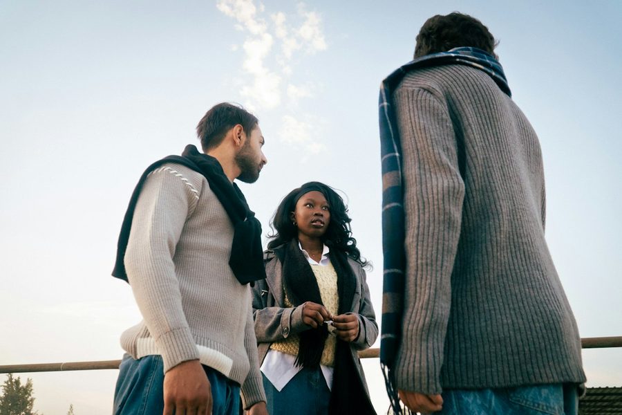 Three people talking together outdoors in warm golden light